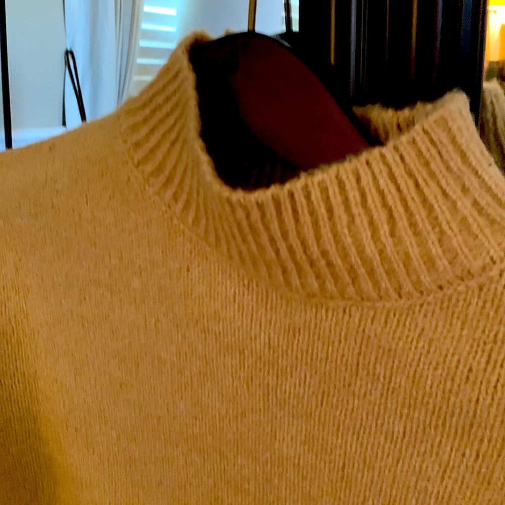 Long sleeved pullover sweater. Has a pocket on the front left side.